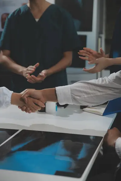 Stock image Doctor handshake and partnership in healthcare, medicine or trust for collaboration, unity or support.Team of medical experts shaking hands in teamwork for or success in hospital