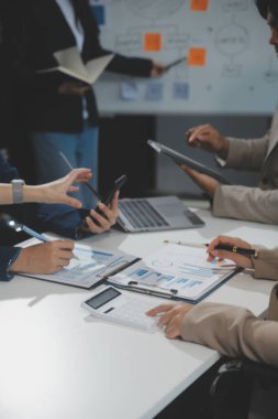 İş ekibi işbirliği mali veriler ve pazarlama büyüme raporlarıyla analiz etmeyi takım halinde, şirket kârından yararlanmak için strateji planlama, sunum ve beyin fırtınası grafiği üzerinde tartışır..