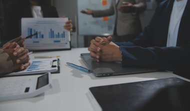 İş ekibi işbirliği mali veriler ve pazarlama büyüme raporlarıyla analiz etmeyi takım halinde, şirket kârından yararlanmak için strateji planlama, sunum ve beyin fırtınası grafiği üzerinde tartışır..