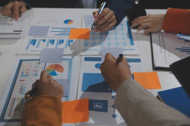 İş ekibi işbirliği mali veriler ve pazarlama büyüme raporlarıyla analiz etmeyi takım halinde, şirket kârından yararlanmak için strateji planlama, sunum ve beyin fırtınası grafiği üzerinde tartışır..