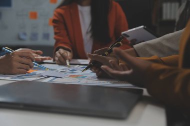 İş ekibi işbirliği mali veriler ve pazarlama büyüme raporlarıyla analiz etmeyi takım halinde, şirket kârından yararlanmak için strateji planlama, sunum ve beyin fırtınası grafiği üzerinde tartışır..