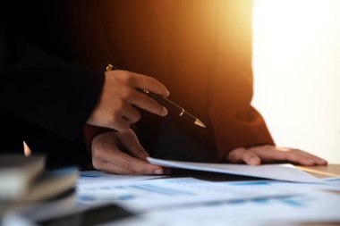 Group of confident business people point to graphs and charts to analyze market data, balance sheet, account, net profit to plan new sales strategies to increase production capacity.
