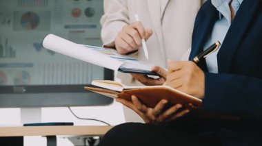 Ofiste finansal tablolar ve grafikler üzerinde çalışan iş ekibi.