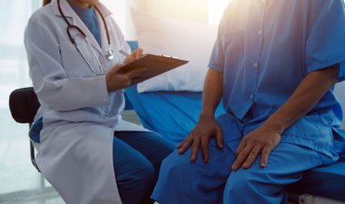 Genç bayan doktor ve hemşireler hastanede konsültasyon yapan yaşlı ve mutlu erkek hastalarla konuşmaya yardım ediyorlar. Değer veren, cesaretlendiren ve olgun erkekleri rahatlatan. sağlık hizmeti kavramı