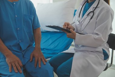 Genç bayan doktor ve hemşireler hastanede konsültasyon yapan yaşlı ve mutlu erkek hastalarla konuşmaya yardım ediyorlar. Değer veren, cesaretlendiren ve olgun erkekleri rahatlatan. sağlık hizmeti kavramı