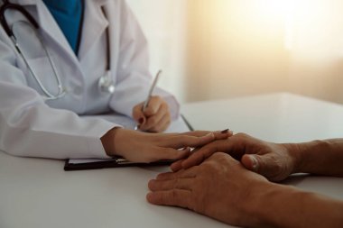 Kadın doktorlar hastaların sağlığını kontrol ederken birbirlerine sevgi, ilgi ve cesaret vermek için birbirlerini cesaretlendiren hastalarla el sıkışıyorlar. Konsept Sağlık ve Sosyal Güvenlik