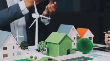 Elinde model ev ve minyatür insanlar tutan iş adamları