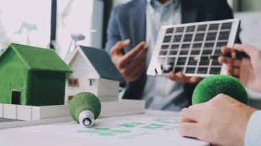 Yeşil evdeki iş adamı bir model tutuyor.