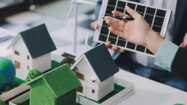 Minyatür insanlar, iş adamları, güneş panelleri olan bir ev tutuyorlar. sürdürülebilir kalkınma ve sürdürülebilir konsept, sürdürülebilir kalkınma