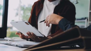 Dijital tabletli ve akıllı telefonlu genç adam ofisinde.