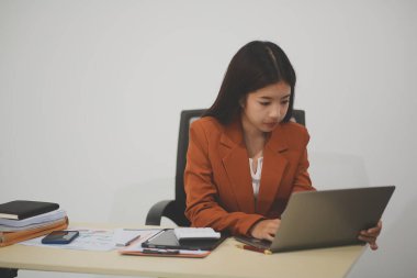 Hırslı ve kendini işine adamış genç bir profesyonel, dizüstü bilgisayarında özenle çalışırken verimliliğini ve detaylara olan ilgisini gösteriyor.