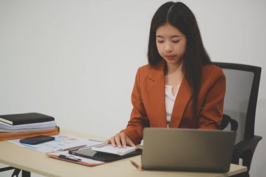 Hırslı ve kendini işine adamış genç bir profesyonel, dizüstü bilgisayarında özenle çalışırken verimliliğini ve detaylara olan ilgisini gösteriyor.