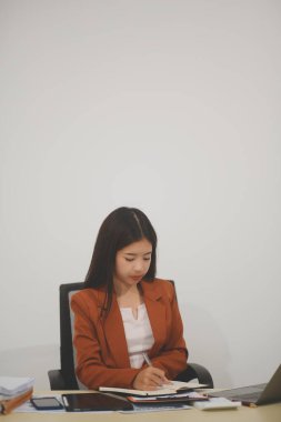 Hırslı ve kendini işine adamış genç bir profesyonel, dizüstü bilgisayarında özenle çalışırken verimliliğini ve detaylara olan ilgisini gösteriyor.