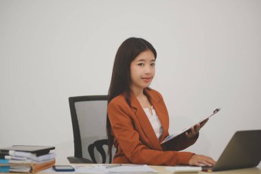 Hırslı ve kendini işine adamış genç bir profesyonel, dizüstü bilgisayarında özenle çalışırken verimliliğini ve detaylara olan ilgisini gösteriyor.