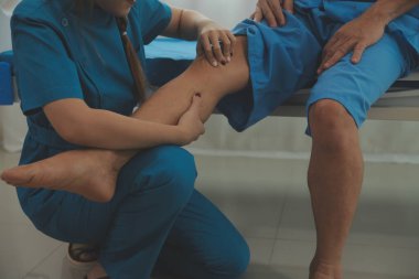 Physical therapists work with patients in close-up clinics. The concept of rehabilitation of physical health, the doctor gives advice to the patient. Ankle problems and muscle injuries