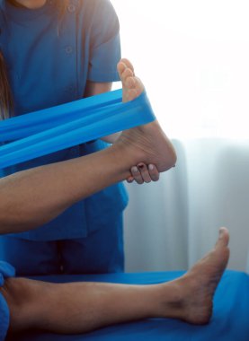 Physical therapists work with patients in close-up clinics. The concept of rehabilitation of physical health, the doctor gives advice to the patient. Ankle problems and muscle injuries