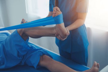 Physical therapists work with patients in close-up clinics. The concept of rehabilitation of physical health, the doctor gives advice to the patient. Ankle problems and muscle injuries