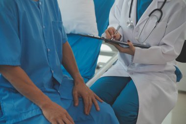 Genç bayan doktor ve hemşireler hastanede konsültasyon yapan yaşlı ve mutlu erkek hastalarla konuşmaya yardım ediyorlar. Değer veren, cesaretlendiren ve olgun erkekleri rahatlatan. sağlık hizmeti kavramı