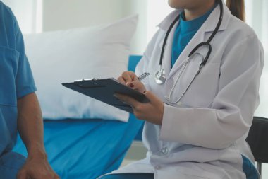 Genç bayan doktor ve hemşireler hastanede konsültasyon yapan yaşlı ve mutlu erkek hastalarla konuşmaya yardım ediyorlar. Değer veren, cesaretlendiren ve olgun erkekleri rahatlatan. sağlık hizmeti kavramı