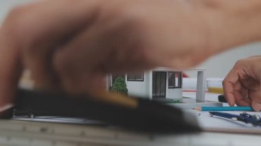 İşçi küçük bir model ev tutuyor. Evin konsepti..