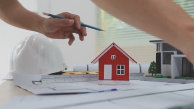 Evin modelini elinde tutan adam planlı, yakın plan.