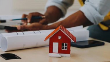 Modeli, sözleşmesi ve hesap makinesi olan bir emlakçı ya da temsilci. ev ofisi ve ev sigortası kavramı