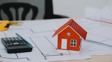 ev modeli ve hesap makinesiyle ev planı.