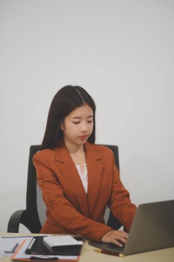 Hırslı ve kendini işine adamış genç bir profesyonel, dizüstü bilgisayarında özenle çalışırken verimliliğini ve detaylara olan ilgisini gösteriyor.