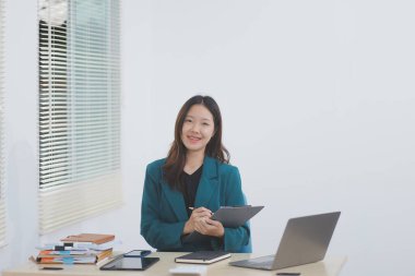 Şirket ofisinde tablet bilgisayarda çalışan Asyalı profesyonel iş kadını.