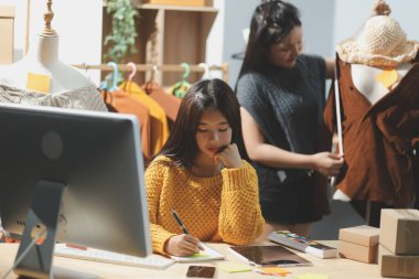 Moda tasarımcıları iş başında. Moda tasarım stüdyosunda çalışan güzel genç bir kadın..