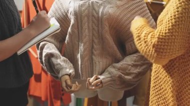 Moda tasarımcısı kıyafetlerini ölçüyor.