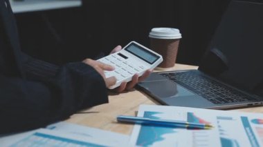 Dizüstü bilgisayarı ve hesap makinesi olan iş adamı