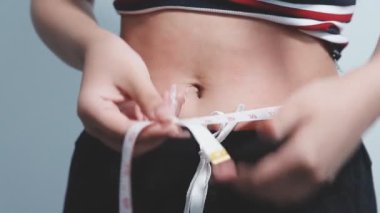 Beyaz iç çamaşırı ve kot pantolon giyen genç bir kadın.