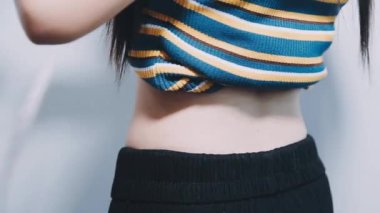 Gri arka planda belini ölçen kadın.