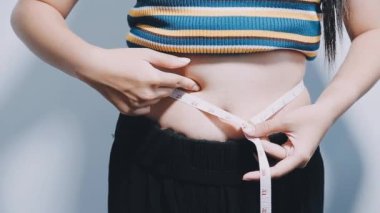 Kadın belini ölçüyor.