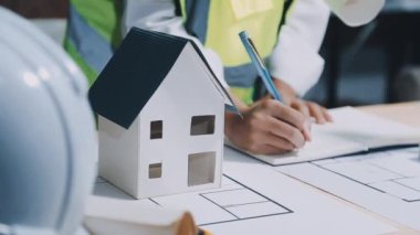 Mimar ya da mühendis ev modelini ve emlak işinin planını tutuyor. İnşaat, emlak, ev inşaatı ve mimari tasarım kavramı.