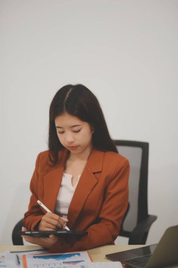 Hırslı ve kendini işine adamış genç bir profesyonel, dizüstü bilgisayarında özenle çalışırken verimliliğini ve detaylara olan ilgisini gösteriyor.