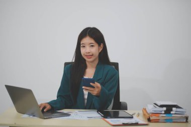 Bilgisayarı ve akıllı telefonu kullanan çekici Asyalı kadın..