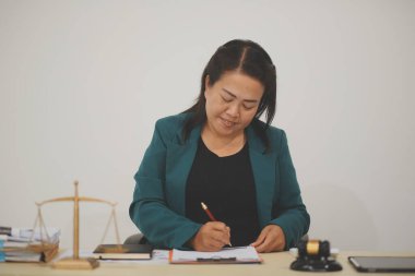 Güzel Asyalı kadın avukat çalışıyor ve çekiç, dizüstü bilgisayar, adalet tavsiyesi ve hukuki kavram. Ofiste.