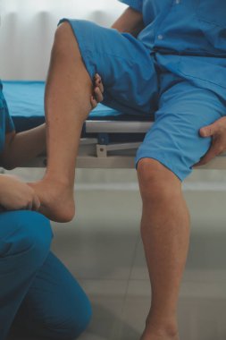 Physical therapists work with patients in close-up clinics. The concept of rehabilitation of physical health, the doctor gives advice to the patient. Ankle problems and muscle injuries