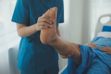 Physical therapists work with patients in close-up clinics. The concept of rehabilitation of physical health, the doctor gives advice to the patient. Ankle problems and muscle injuries