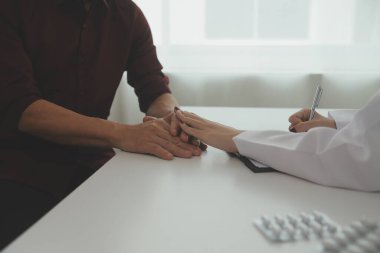 Kadın doktorlar hastaların sağlığını kontrol ederken birbirlerine sevgi, ilgi ve cesaret vermek için birbirlerini cesaretlendiren hastalarla el sıkışıyorlar. Konsept Sağlık ve Sosyal Güvenlik