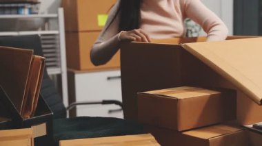 Ofiste kutuları olan kadın.