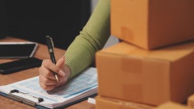 İş kadını dizüstü bilgisayarı üzerinde çalışıyor ve müşterilerine bir paket gönderiyor. çevrimiçi dağıtım.