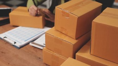 Paketle karton kutu paketleyen bir adam