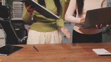 Genç Asyalı iş kadınları iş yerinde tablet ve laptop kullanıyorlar..