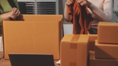 Kadın işçi karton kutu paketliyor.