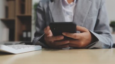 İş adamı masadaki akıllı telefonu kullanıyor