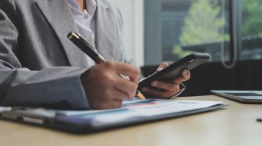 İş adamı elinde akıllı bir telefon ve kalemle tablet kullanıyor..