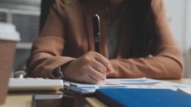 iş kadını kalemle not defterine el yazısı